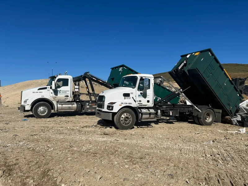 WRS roll off trucks tipping green containers at a disposal site